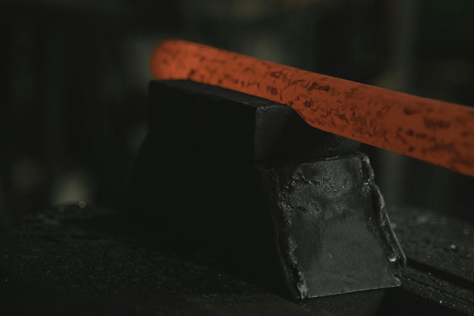 Glowing red-hot steel bar emerging from the rolling mill